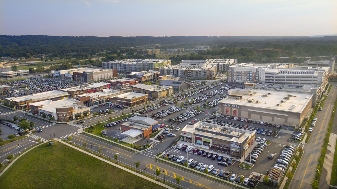 Aerial view of an expansive mixed use town center village with retail, multifamily, and parking structures