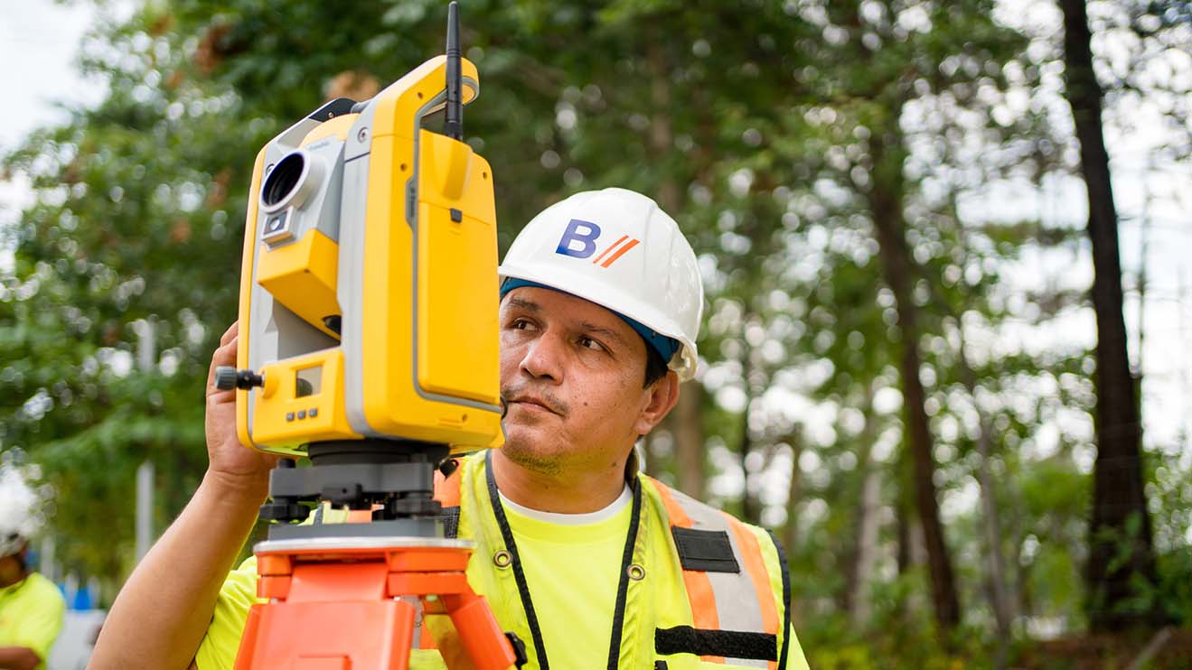 A land surveyor using survey equipment