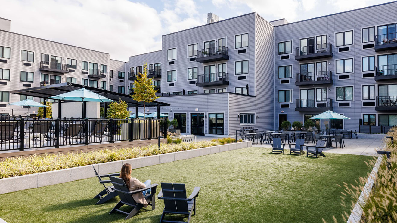 A woman relaxing in a lounge chair in an amenity courtyard