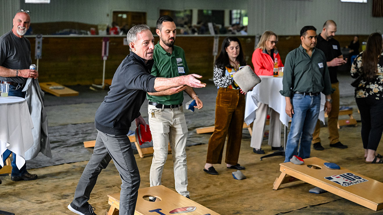 People throwing cornhole bags, cornhole tournament