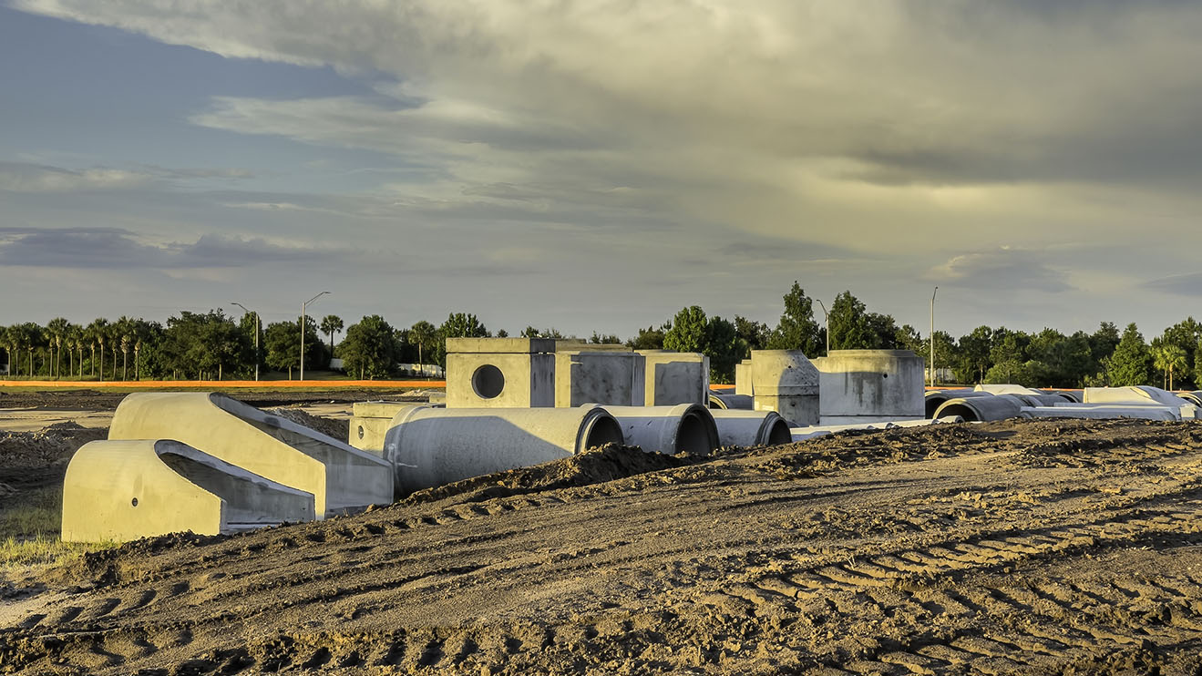 Precast concrete connectors and pipes for stormwater drainage on a construction site of a future housing development near sunset in west central Florida